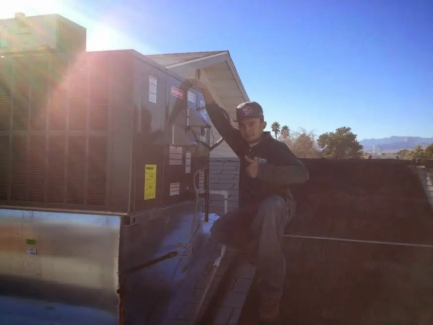 HVAC technician performing AC Tune-Up on a rooftop unit in Northborough